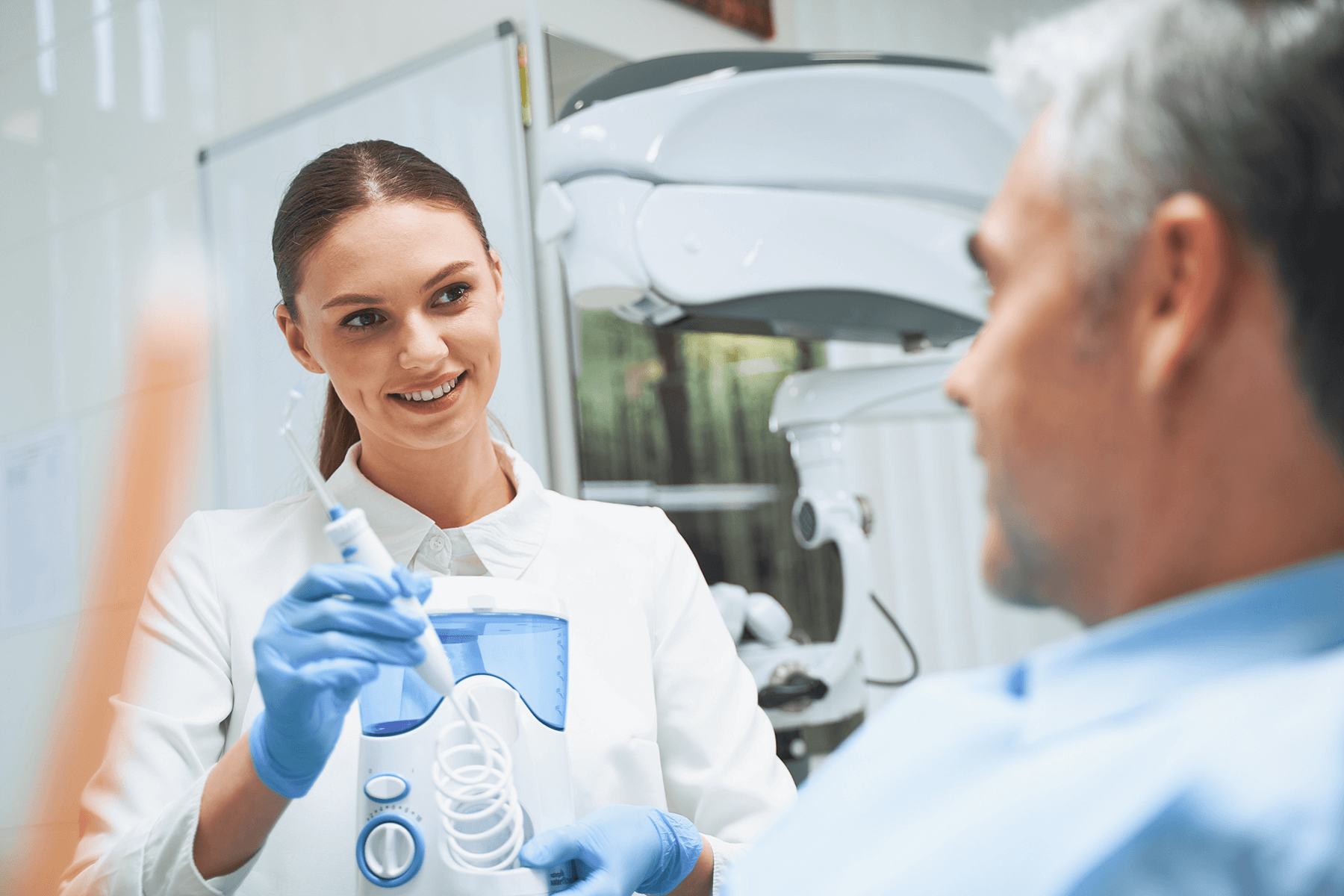 Zahnärztin und älterer Patient Zahnärztin spricht mit einem älteren Patienten in der Praxis, freundlicher und fachkundiger Austausch.